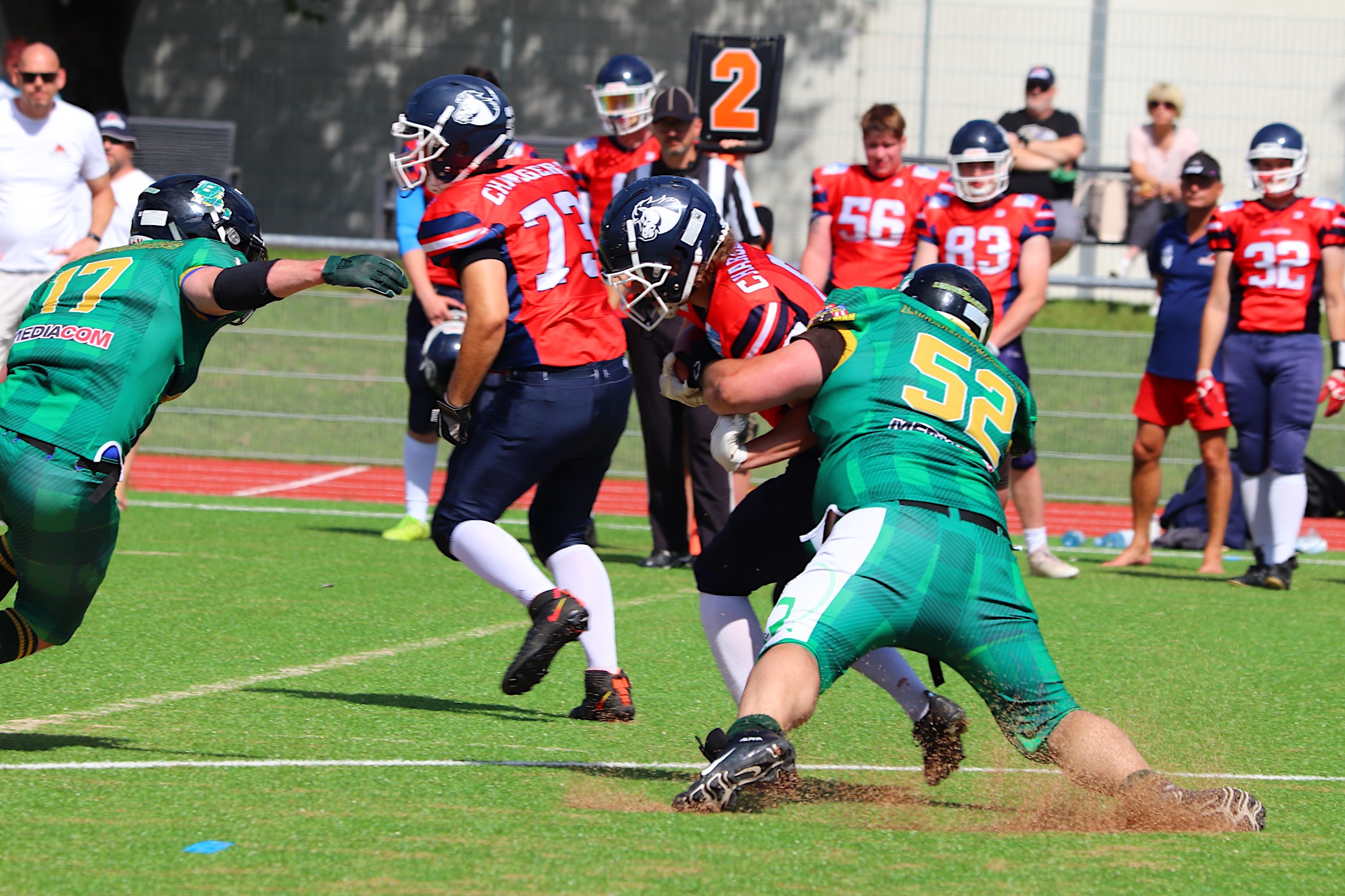 Die Defense der Brilon Lumberjacks (in grün) hatte im Spiel gegen die Recklinghausen Chargers einige starke Szenen. Hier stoppt Headcoach Chris Nehls (Nr. 52) einen Angriff. Die Niederlage konnte sie letztendlich nicht verhindern. (Foto: Mario Polzer)